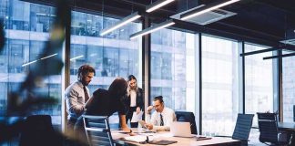 Netflix Cuts 1,000 Jobs in Major Shake-Up Business team collaborating at a conference table in a modern glass-walled office
