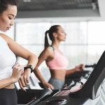 Elite Runner Dies Night Before Marathon Woman on treadmill checking smartwatch in gym