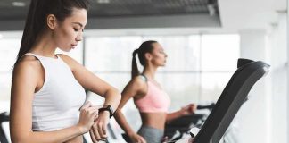 Elite Runner Dies Night Before Marathon Woman on treadmill checking smartwatch in gym