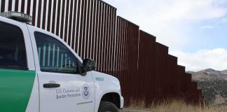 Judge Pauses Big Bend Border Work Border patrol SUV parked beside tall steel border fence
