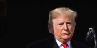 Trump Insults Reporter Over Controversial Campaign Ad Donald Trump at a podium with a microphone