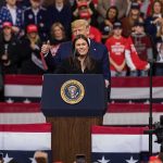 Market Gains, Marriage Gains? Donald Trump stands behind a speaker at a rally; Frank Wycheck and B. J. Daniels are present in the crowd