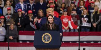 Market Gains, Marriage Gains? Donald Trump stands behind a speaker at a rally; Frank Wycheck and B. J. Daniels are present in the crowd