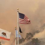 American Flag Survives California Blaze American flag and California flag amid smoky wildfire sky