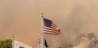 American Flag Survives California Blaze American flag and California flag amid smoky wildfire sky