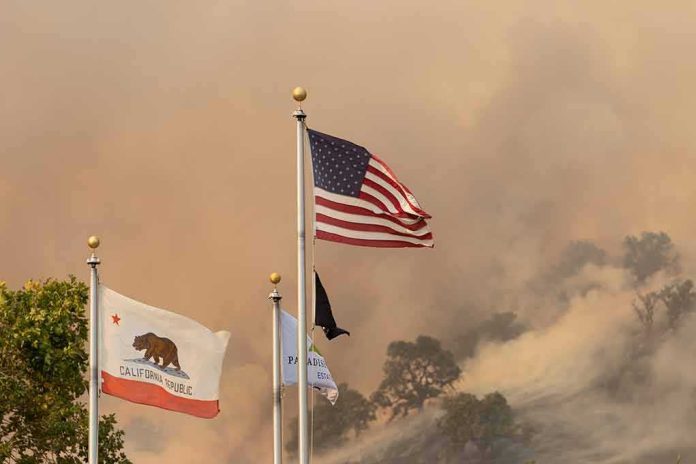 shutterstock_1799473666 American flag and California flag amid smoky wildfire sky