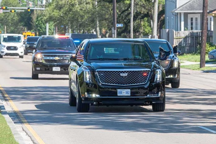 shutterstock_1969534900 Motorcade of black SUVs and sedans driving down a city street