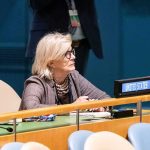 Woman seated at a United Nations desk with a United States nameplate