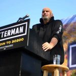 California Targets Homeless Camps by 2027 Speaker at outdoor podium with campaign signs