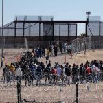 Israel Closes West Bank, Gaza Crossings Crowd of people lining up near a border fence with barbed wire