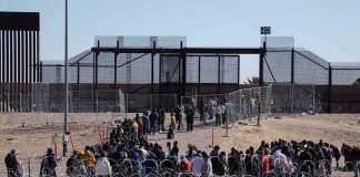 Israel Closes West Bank, Gaza Crossings Crowd of people lining up near a border fence with barbed wire